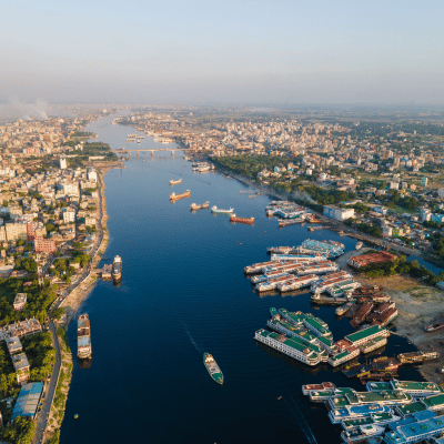 Vue aérienne d’un port fluvial asiatique avec trafic maritime et ville en arrière-plan – Nexline Group