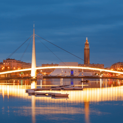 Vue nocturne du port du Havre avec pont illuminé et tour de l’hôtel de ville – Nexline Group
