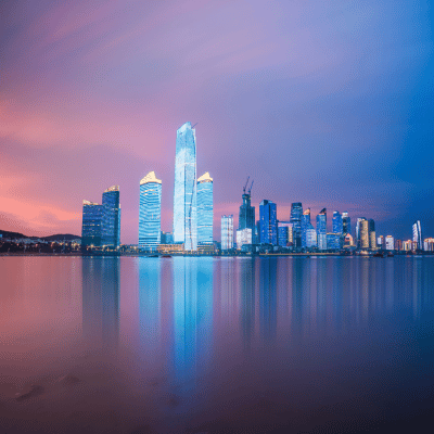 Vue nocturne de la skyline de Qingdao, reflet sur l’eau, symbole de l’expansion de Nexline en Asie