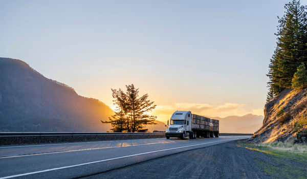 Camion sur la route au lever du soleil – logistique routière longue distance Nexline