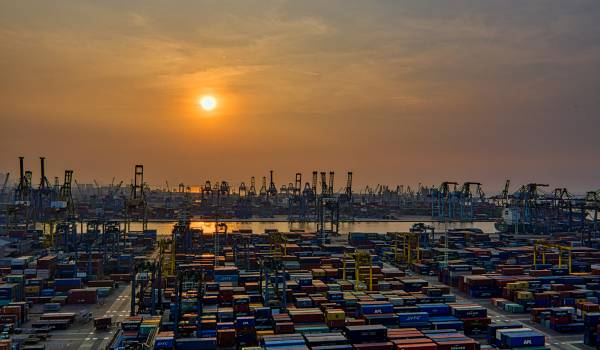 Port with containers at sunset, illustrating Nexline’s multimodal transport solutions